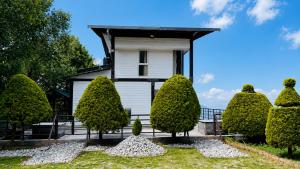 a white house with trees in front of it at Sky Villa Ramgarh Mukteshwar in Mukteshwar