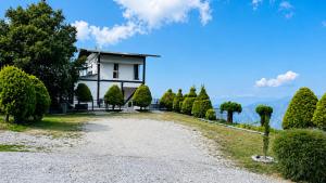 a house on a hill with a gravel driveway at Sky Villa Ramgarh Mukteshwar in Mukteshwar