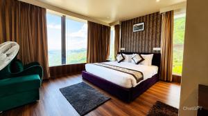 a hotel room with a bed and a large window at Sky Villa Ramgarh Mukteshwar in Mukteshwar