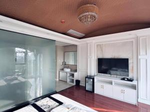 a living room with a large television and a chandelier at 伟信名人酒店 in Sihanoukville