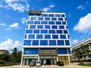 a tall building with cars parked in front of it at 伟信名人酒店 in Sihanoukville +9 photos