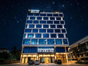 a tall building with cars parked in front of it at 伟信名人酒店 in Sihanoukville