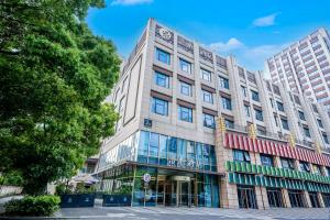 a large building with glass windows on a street at Manxin Hotel Suzhou Jinfeng Road in Suzhou