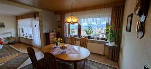 a dining room with a table and a kitchen with a window at FeWo Christa in Marpingen