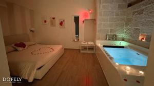 a bedroom with a tub and a bed and a bed and a tub at Dofely Suites - Gelso in Polignano a Mare