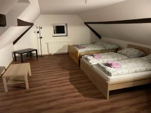 a room with two beds and a table in it at Statek U Dubu in Svojetín +13 photos