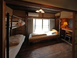 a bedroom with two bunk beds and a window at Ukiwa Guest House in Shimoda
