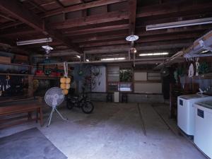 a garage with a fan and a bike in it at Ukiwa Guest House in Shimoda