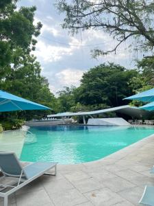 a swimming pool with chairs and a bridge at Tambuli Seaside Living Pad seaview in Maribago