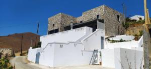 a white house with stairs on the side of it at Casa Petra Astypalea in Astypalaia