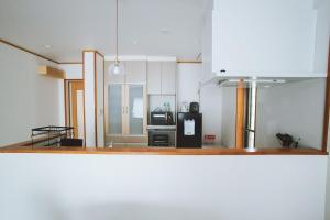 a kitchen with a stove and a refrigerator at 星空テラスと海一望 静寂に包まれる屋上BBQ Resort Villa ManMaka in Miyakojima