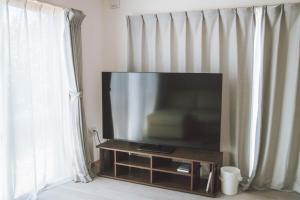 a flat screen tv sitting on a stand next to a window at 星空テラスと海一望 静寂に包まれる屋上BBQ Resort Villa ManMaka in Miyakojima +22 photos