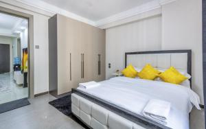 a bedroom with a large white bed with yellow pillows at Kindaruma Homes Apartments in Nairobi