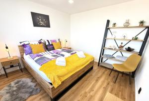 a bedroom with a bed with yellow and purple pillows at Sky View Apartmán 10 patro in Břeclav