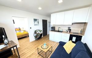 a living room with a blue couch and a kitchen at Sky View Apartmán 10 patro in Břeclav