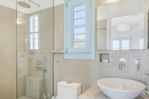 a bathroom with a sink and a toilet and a window at Beachfront Ios Villa in Ios Chora +41 photos