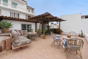 a patio with a couch and chairs and tables at Casa Terraza in La Herradura