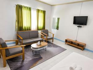 a living room with a couch and a tv at Allisa Resort Hotel in Anyer