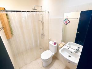a bathroom with a toilet and a shower and a sink at Allisa Resort Hotel in Anyer