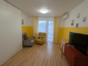 a living room with two chairs and a television at Lovely Studio with a Balcony in Sinemorets