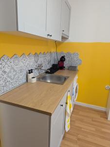 a kitchen with a sink and a yellow wall at Lovely Studio with a Balcony in Sinemorets +16 photos