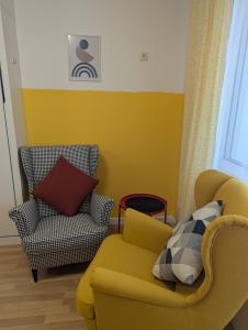 a living room with a yellow couch and a chair at Lovely Studio with a Balcony in Sinemorets