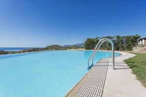 a large swimming pool with a metal handrail next to it at Casa Margarita in Tertenìa