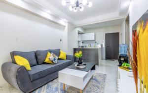 a living room with a gray couch and yellow pillows at Kindaruma Homes Apartments in Nairobi +36 photos