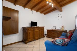 a living room with a blue couch and a tv on a wooden cabinet at I Bibi Vacation Home in Viareggio
