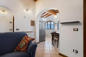 a living room with a blue couch and a kitchen at I Bibi Vacation Home in Viareggio