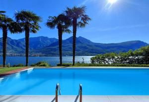 ein Swimmingpool mit Palmen und Blick auf das Wasser in der Unterkunft Villa Maria in Onno
