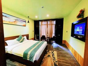 a hotel room with a bed and a flat screen tv at Chitwan Grand Regency in Bharatpur