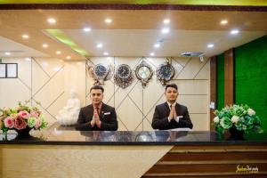 two men in suits sitting at a table with theirselves at Chitwan Grand Regency in Bharatpur +16 photos