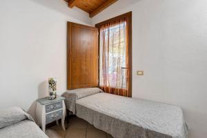 two twin beds in a room with a window at I Bibi Vacation Home in Viareggio