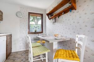 a kitchen with a table and chairs with yellow cushions at Ferienhaus Cajo in Dahmen