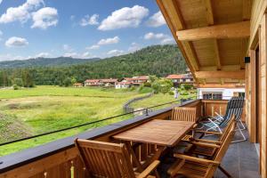 a balcony with a wooden table and chairs and a view at Haus Stoabock in Wallgau