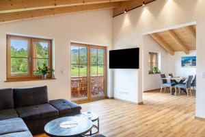 a living room with a couch and a tv at Haus Stoabock in Wallgau