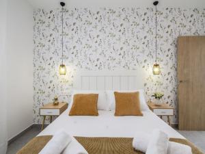 a bedroom with a white bed and a floral wallpaper at Casa Regalo in Dúrcal +32 photos