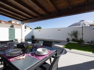a dining table on a patio with an umbrella at Casa Regalo in Dúrcal