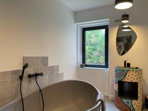 a bathroom with a tub and a window at Big Jungle in Grane +7 photos
