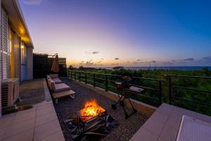 a fire pit on a balcony with a view of the ocean at COCO VILLLA 沖縄今帰仁-Okinawa nakijin in Nakijin