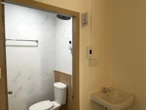 a bathroom with a white toilet and a sink at The Kanee Hostel in Nakhon Phanom +37 photos