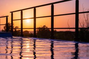 a swimming pool with the sunset in the background at COCO VILLLA 沖縄今帰仁-Okinawa nakijin in Nakijin