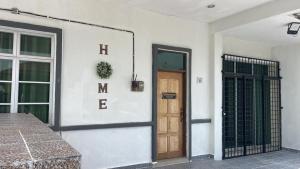 a front door of a white building with the word mistress at Legacy Yumai in Kuala Rompin