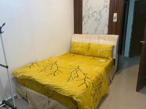 a yellow comforter on a bed in a room at Legacy Yumai in Kuala Rompin +5 photos