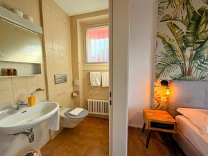 a bathroom with a sink and a toilet at Garden Hotel Primavera in Brissago +116 photos