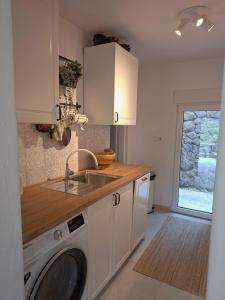 a kitchen with a sink and a washing machine at Villa Arboreta in Tuhelj +34 photos