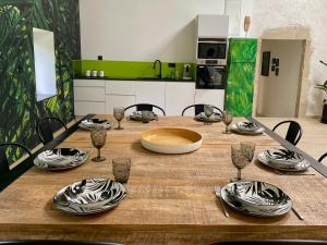 a wooden table with plates and wine glasses on it at Big Jungle in Grane