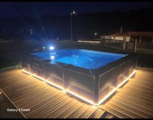a swimming pool with lights on a deck at night at Casa vieira in Bico