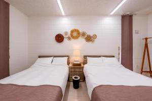 two beds sitting next to each other in a room at COCO VILLLA 沖縄今帰仁-Okinawa nakijin in Nakijin +84 photos